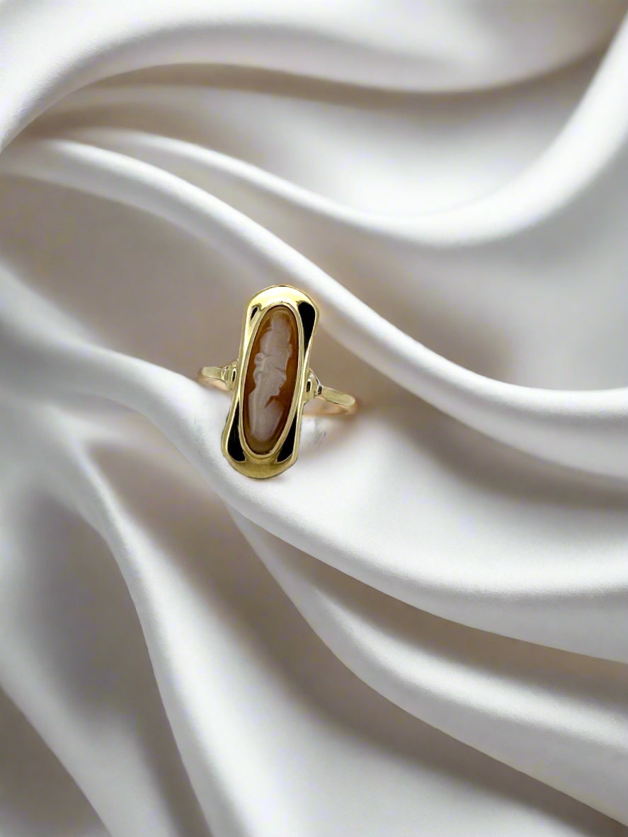 De Juwelier van der Kooij vintage gouden ring 14k 1.9gr, met zijn ovale design en gegraveerde camee profiel, rust prachtig op ivoor zijde stof. De ingewikkelde details van dit stuk en de glans van de zijde creëren een opvallend contrast.