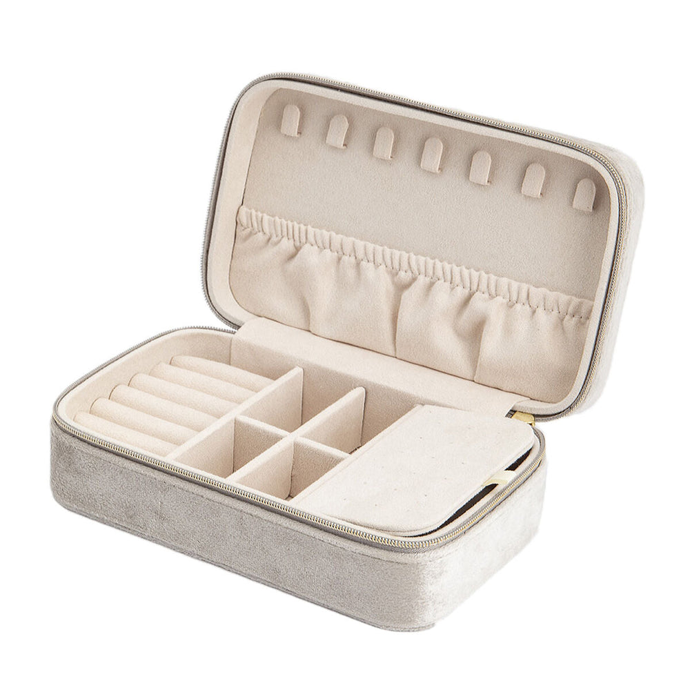 De Van der Kooij Collectie sieradendoos creme toebehoren is een beige fluwelen sieraden organizer voor dames met een open deksel, ringsleuven, verdelers, elastisch zakje, kettinghaakjes binnenin en een veilige ritssluiting.