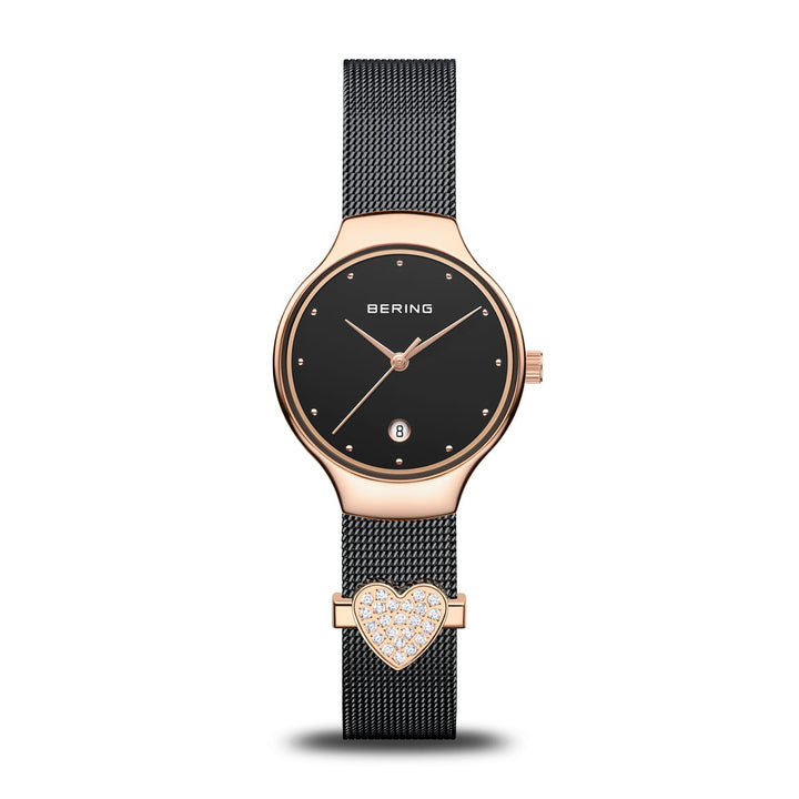 De Bering 13326-262-GWP, een quartz dameshorloge, heeft een ronde zwarte wijzerplaat en een zwarte mesh band. De roestvrijstalen kast en lunette hebben een elegante roségouden afwerking, aangevuld met een hartvormige kristallen bedel voor extra verfijning.