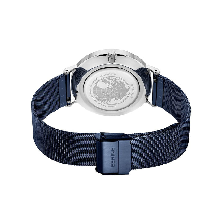 De Bering heren horloge blauw 14040-307 heeft een zilverkleurige kast met een gegraveerd kaartontwerp, een donkerblauwe mesh band en het BERING logo op de sluiting en de rand. Het horloge is afgebeeld vanaf de achterkant.