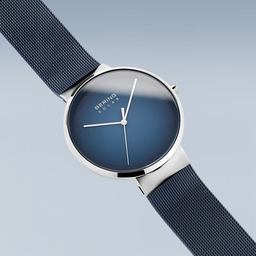 Het Bering unisex horloge 14339-307 heeft een strak, minimalistisch design met een blauwe wijzerplaat en zilveren kast, aangevuld met een blauwe mesh band. Een elegant accessoire voor liefhebbers van moderne stijl.