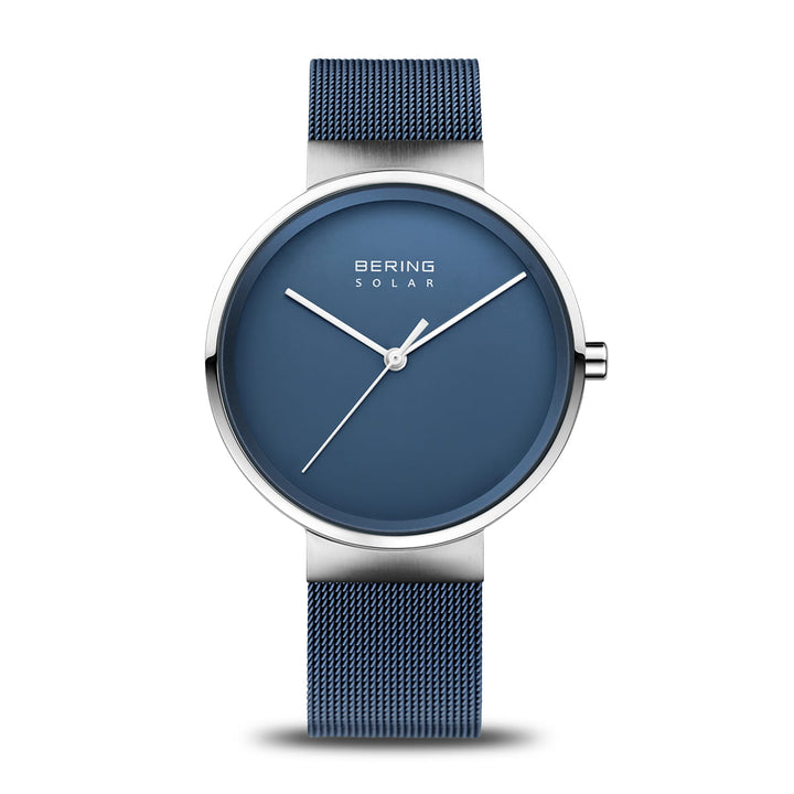 Dit elegante Bering polshorloge, model 14339-307, heeft een blauwe wijzerplaat met minimalistische zilveren uur- en minutenwijzers, geen cijfers, de tekst Bering Solar Horloge, een bijpassende blauwe mesh-band en een zilveren lunette voor een moderne stijl.