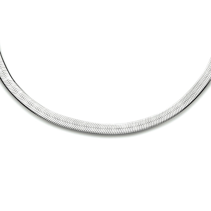 Een close-up van de Van der Kooij Collectie collier slang plat 3,3 mm 40 + 5 cm in gerhodineerd zilver, met een strak, plat ontwerp met een subtiele zigzagstructuur, afgebeeld tegen een effen witte achtergrond.