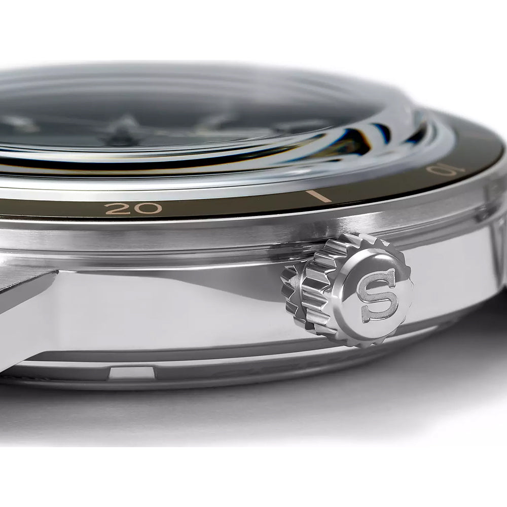 Een close-up van het Seiko Presage heren horloge SRPG07J1 toont de zilveren kast met een zwarte lunette met gouden cijfers die 20 markeren. Het gewelfde kristal benadrukt het zijprofiel van de automatische uurwerkkast en de kroon heeft een gegraveerde S.