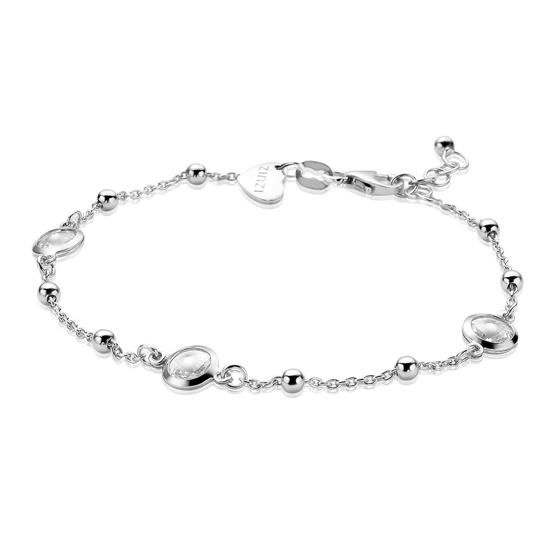 De Zinzi Armband Zilver Zia1550 heeft een zilveren armband met kleine kralen en ovaalvormige bedels aan een delicate ketting, vastgezet met een karabijnsluiting. Een hartvormig label bij de sluiting voegt elegantie toe aan het minimalistische ontwerp.