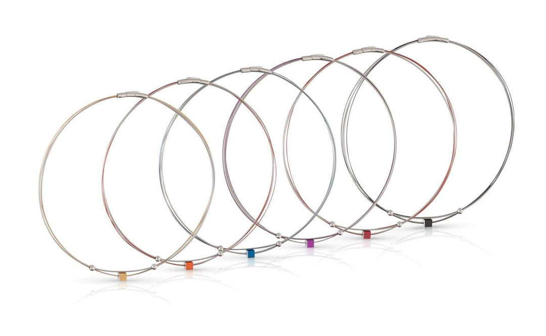 De Collier Klein Kubusje Blauw C230B van CLIC Creations heeft zeven metaalkleurige draadkabels, elk met een gekleurd label in roze, oranje, rood, paars, blauw, groen en zwart. Dit verbluffende stuk integreert een bajonetsluiting voor extra flair.