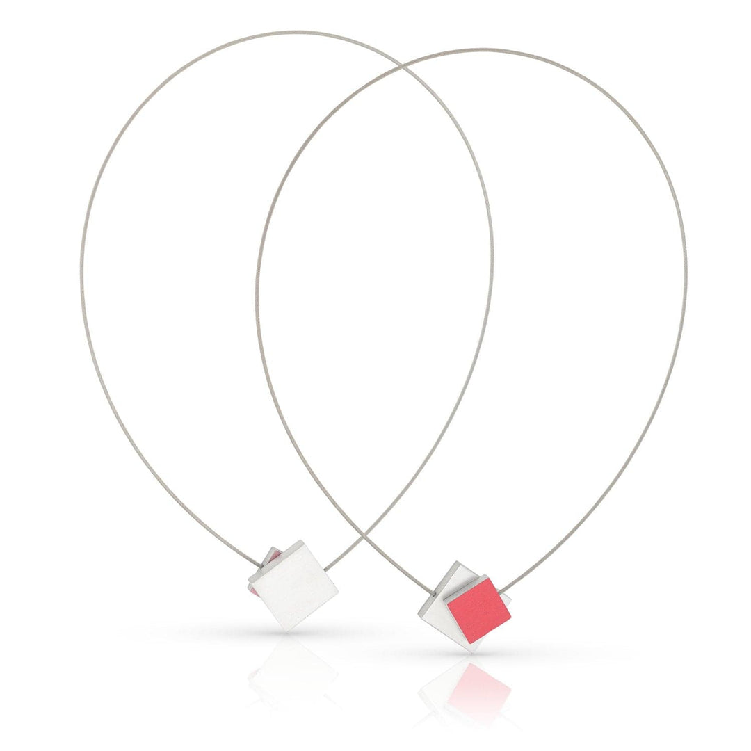 CLIC Creations Collier Vierkant met gekleurd vierkant C263R bevat twee minimalistische kettingen met draadlussen en centrale kubussen, een rode en een witte. De elegante druppelvormen versterken het geometrische ontwerp, terwijl de magnetische sluiting zorgt voor gemakkelijk dragen. Perfect voor elk stijlvol ensemble.