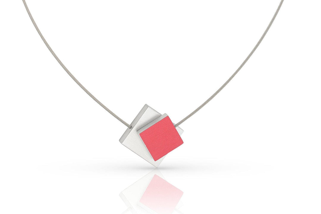 De Collier Vierkant met gekleurd vierkant C263R van CLIC Creations heeft een minimalistisch ontwerp met een geometrische hanger van overlappende zilveren en rode ruitvormige stukken aan een dunne metalen ketting. Het heeft een magnetische sluiting voor stijl en gemak tegen een schone witte achtergrond.