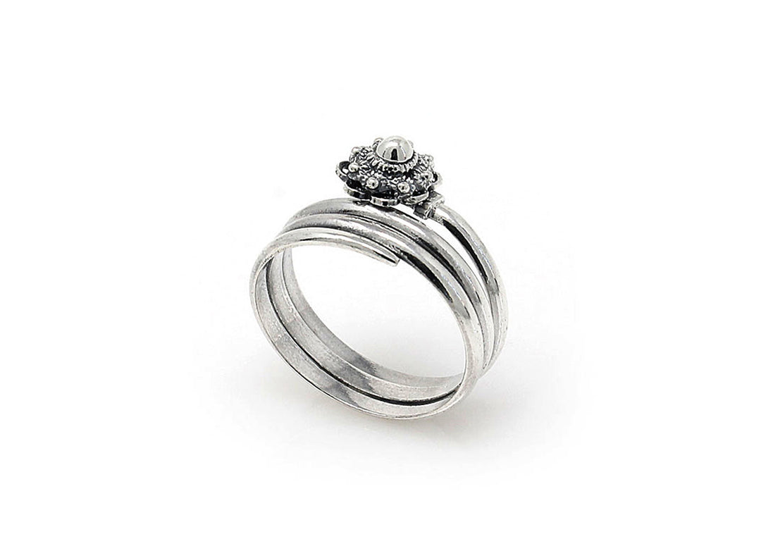 De Dutch Button Zeeuwse Knoop Ring Zilver nr 10 heeft een gladde zilveren band en een sierlijke bloemachtige zetting zonder centrale steen. De ingewikkelde details zorgen voor een elegante en verfijnde uitstraling tegen een witte achtergrond.
