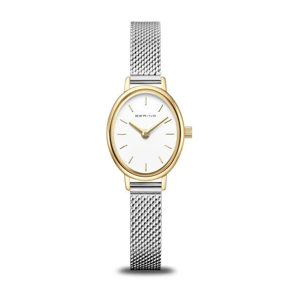 De Bering 11020-010 dameshorloge heeft een witte ovale wijzerplaat, gouden lunette, minimale markeringen, zilverkleurige mesh band, duurzaam saffierglas en een nauwkeurig quartz uurwerk - dit alles elegant weergegeven op een witte achtergrond.