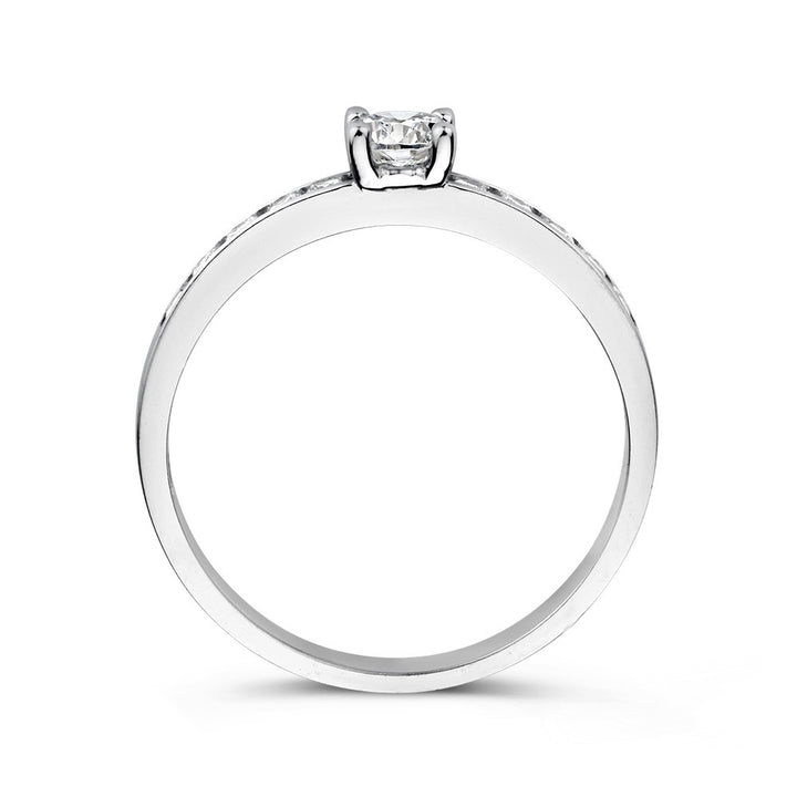 Een close-up van de Witgouden Damesring met Zirkonia's - Subtiele Elegantie van Excellent Jewelry, met een delicate zirkonia met tandjes, tegen een witte achtergrond.