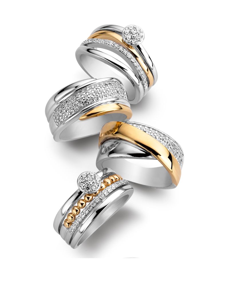 Vier opvallende ringen van Excellent Jewelry hebben gestapelde banden van 14 karaat geelgoud en gerhodineerd zilver, geaccentueerd met schitterende zirkonia's voor een gedurfde, elegante look. Product: Zilveren Damesring met 14 Karaat Goud en Zirkonia's - Geelgoud.