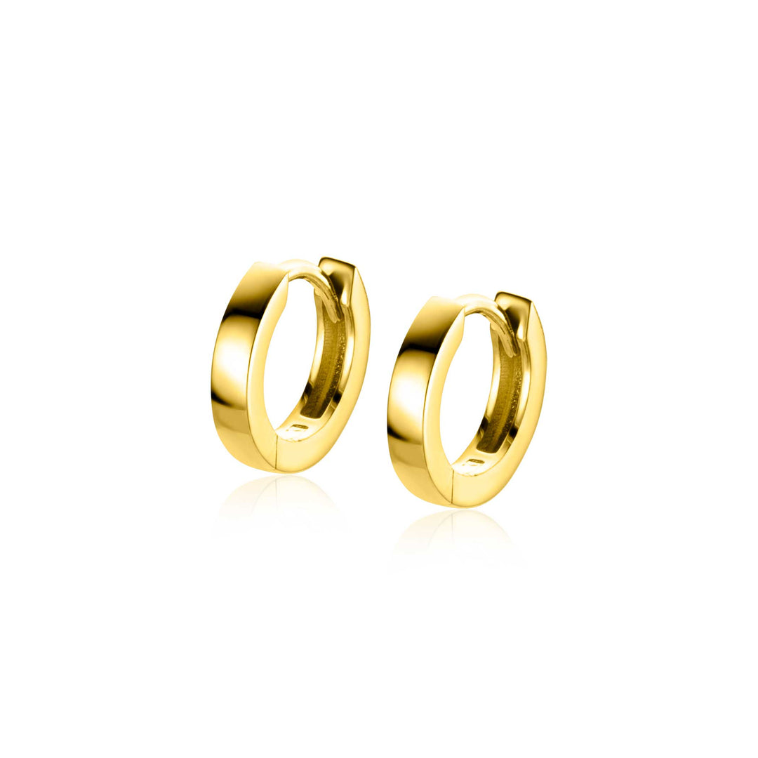 De Zinzi Oorbellen Goud Zgo427 zijn strakke en gepolijste gouden oorbellen die op een witte achtergrond worden weergegeven, met een glad, reflecterend oppervlak. Hun elegante ontwerp omvat een luxe klapsluiting en ronde vorm, wat de verfijning versterkt omdat ze parallel aan elkaar zitten.