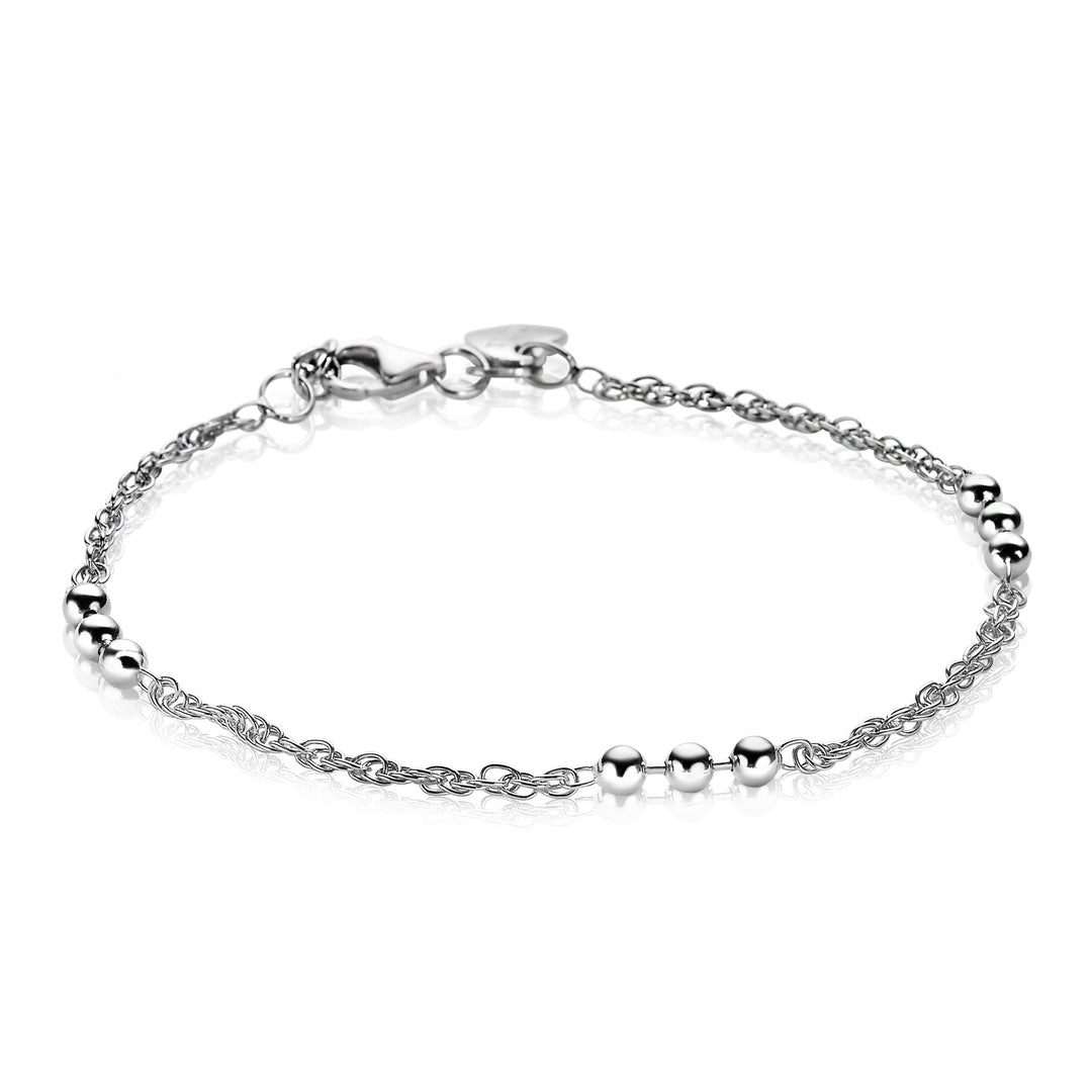 De Zinzi Armband Zilver Zia1422, een delicate fantasiearmband van Zinzi, heeft een zilveren ketting met gepolijste kralen en een veilige karabijnsluiting. Het bevat een charmant hart bij de sluiting en is geplaatst tegen een witte achtergrond.